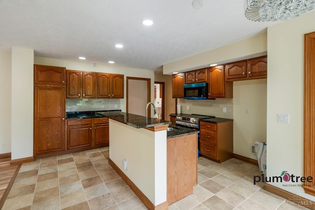 378 Natalie Ln, Turtle Creek Twp, OH 45036 - kitchen featuring black microwave, a sink, brown cabinetry, backsplash, and recessed lighting