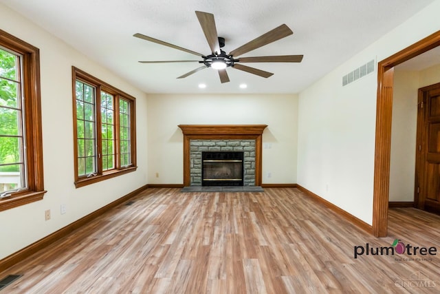 378 Natalie Ln, Turtle Creek Twp, OH 45036 - unfurnished living room with light wood-style flooring, plenty of natural light, ceiling fan, a stone fireplace, and recessed lighting