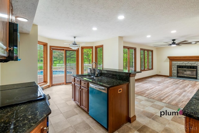 378 Natalie Ln, Turtle Creek Twp, OH 45036 - kitchen featuring dishwashing machine, a sink, recessed lighting, brown cabinets, and dark stone countertops
