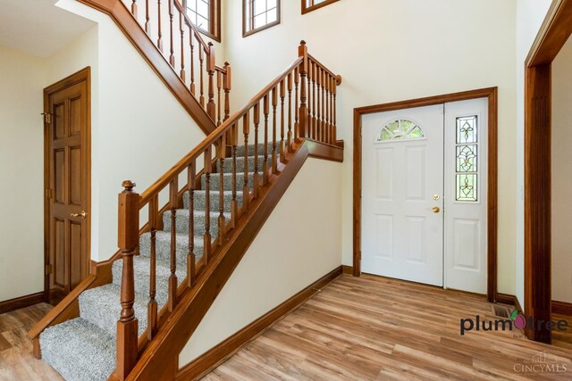 378 Natalie Ln, Turtle Creek Twp, OH 45036 - foyer with wood finished floors, healthy amount of natural light, baseboards, stairway, and a towering ceiling
