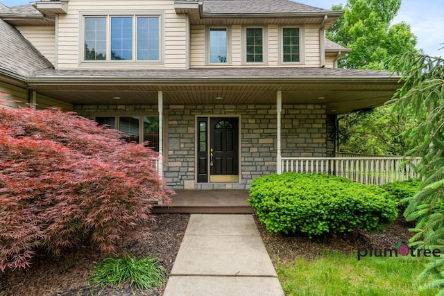 378 Natalie Ln, Turtle Creek Twp, OH 45036 - doorway to property featuring covered porch, stone siding, and roof with shingles