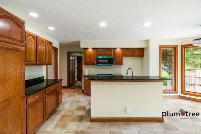 378 Natalie Ln, Turtle Creek Twp, OH 45036 - kitchen featuring black microwave, dark stone counters, a sink, decorative backsplash, and baseboards
