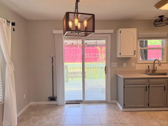 232 Choctaw Cir, Franklin, OH 45005 - kitchen with a sink, healthy amount of natural light, baseboards, hanging light fixtures, and a textured ceiling