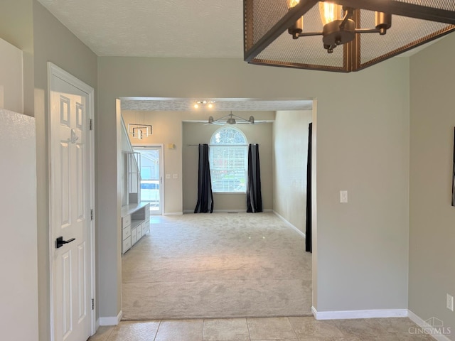 232 Choctaw Cir, Franklin, OH 45005 - hallway featuring light carpet, a chandelier, and baseboards