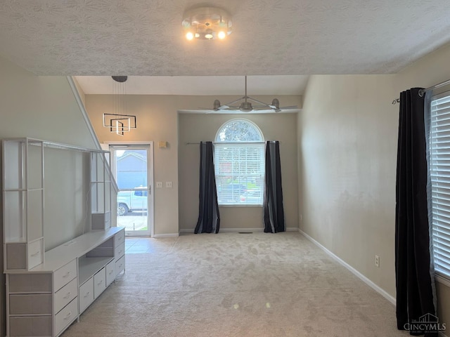 232 Choctaw Cir, Franklin, OH 45005 - unfurnished living room with light colored carpet, baseboards, and a textured ceiling