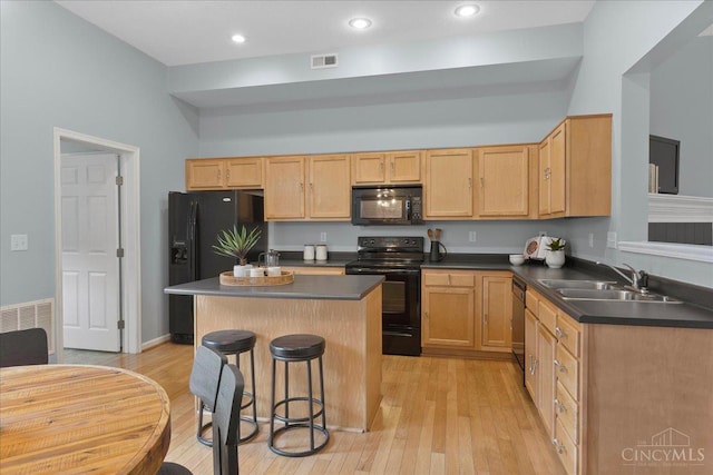 1441 Laurel Park Dr, Cincinnati, OH 45214 - kitchen with black appliances, a sink, dark countertops, light brown cabinetry, and a breakfast bar area
