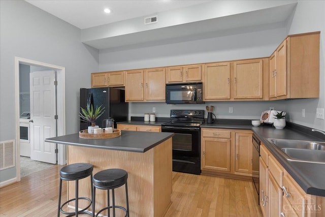 1441 Laurel Park Dr, Cincinnati, OH 45214 - kitchen with black appliances, dark countertops, a sink, a breakfast bar, and recessed lighting