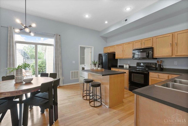 1441 Laurel Park Dr, Cincinnati, OH 45214 - kitchen with black appliances, dark countertops, light brown cabinets, a kitchen island, and light wood-style floors