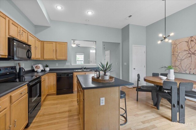 1441 Laurel Park Dr, Cincinnati, OH 45214 - kitchen featuring black appliances, dark countertops, a kitchen breakfast bar, and light wood finished floors