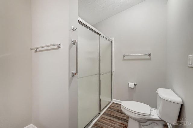 10350 W Rd Unit 34, Harrison, OH 45030 - bathroom featuring toilet, a stall shower, wood finished floors, and baseboards