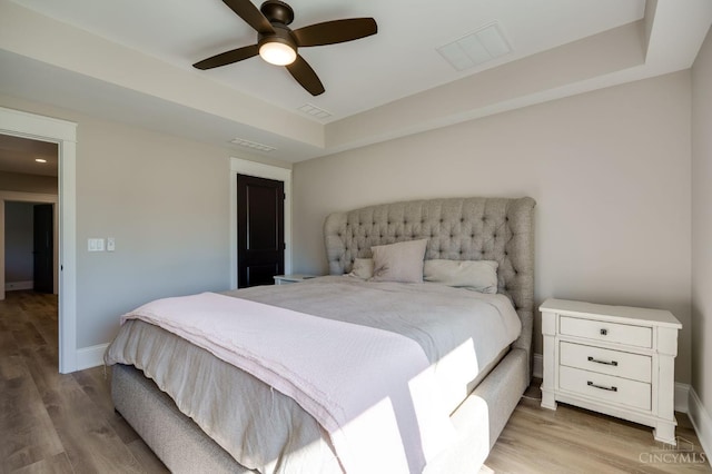 1941 Legendary Way, Clearcreek Twp, OH 45036 - bedroom featuring a tray ceiling, light wood-style flooring, ceiling fan, and baseboards