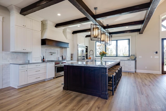 1941 Legendary Way, Clearcreek Twp, OH 45036 - kitchen with high end appliances, custom exhaust hood, light wood finished floors, decorative backsplash, and beamed ceiling