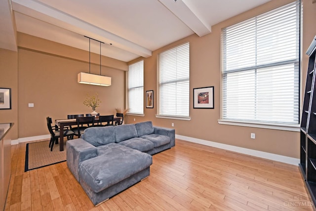 15 W Fourth St Unit 413, Cincinnati, OH 45202 - living area featuring a wall unit AC, beam ceiling, light wood finished floors, and baseboards