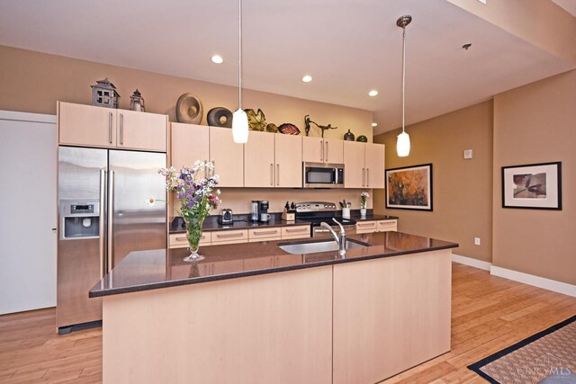 15 W Fourth St Unit 413, Cincinnati, OH 45202 - kitchen featuring stainless steel appliances, a sink, light wood-style floors, a kitchen island with sink, and recessed lighting