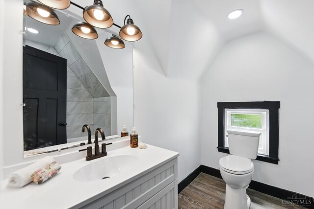 752 S Fred Shuttlesworth Cir, Cincinnati, OH 45229 - bathroom featuring wood finished floors, toilet, vanity, lofted ceiling, and baseboards