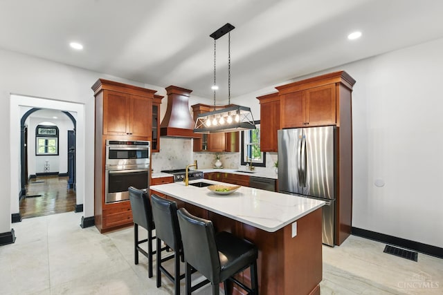 752 S Fred Shuttlesworth Cir, Cincinnati, OH 45229 - kitchen featuring stainless steel appliances, custom exhaust hood, tasteful backsplash, a kitchen island with sink, and recessed lighting