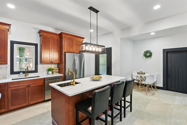 752 S Fred Shuttlesworth Cir, Cincinnati, OH 45229 - kitchen featuring appliances with stainless steel finishes, a sink, tasteful backsplash, an island with sink, and a kitchen breakfast bar