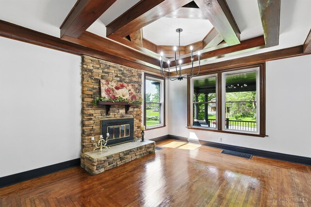 752 S Fred Shuttlesworth Cir, Cincinnati, OH 45229 - unfurnished living room with a chandelier, plenty of natural light, a stone fireplace, baseboards, and beamed ceiling
