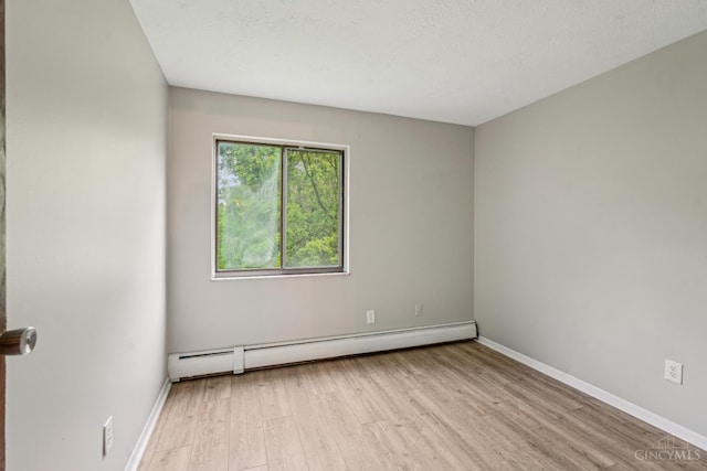 6644 Hearne Rd Unit 202, Green Twp, OH 45248 - spare room featuring baseboard heating, wood finished floors, and baseboards