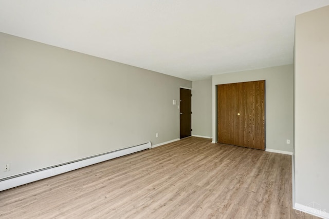 6644 Hearne Rd Unit 202, Green Twp, OH 45248 - unfurnished bedroom featuring baseboard heating, light wood-type flooring, a closet, and baseboards