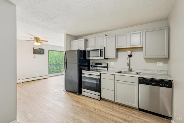 6644 Hearne Rd Unit 202, Green Twp, OH 45248 - kitchen with appliances with stainless steel finishes, baseboard heating, a sink, a textured ceiling, and light countertops