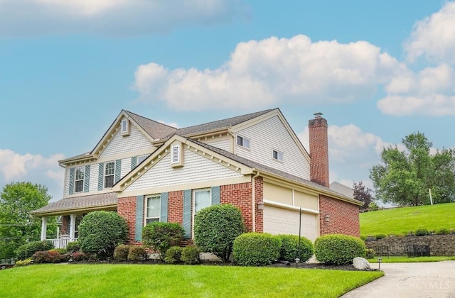 5509 Windmere Dr, Green Twp, OH 45248 - view of front facade featuring brick siding, a front yard, and a chimney