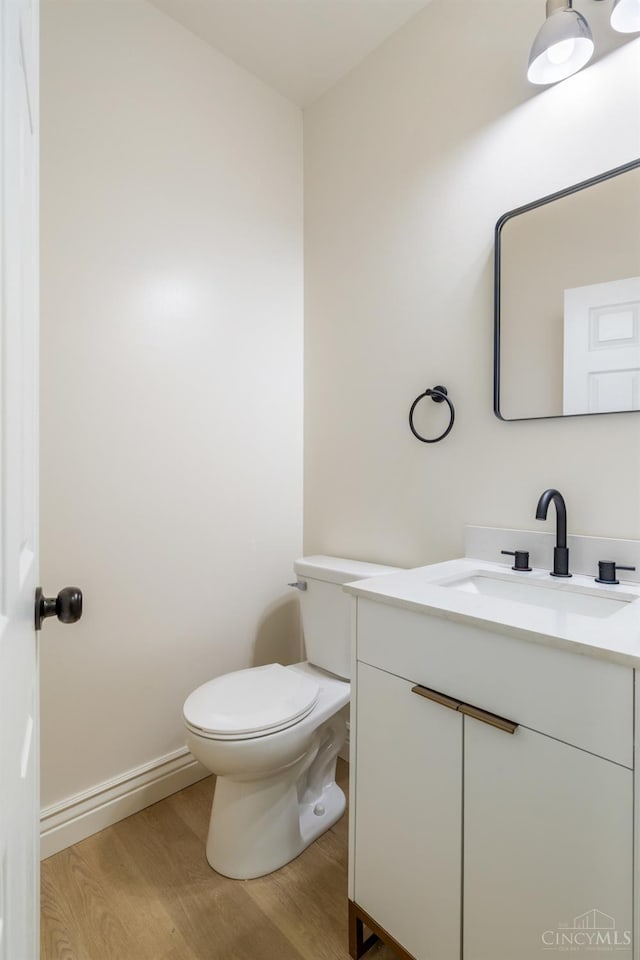 926 Shuler Ave, Hamilton, OH 45011 - half bathroom with wood finished floors, vanity, toilet, and baseboards