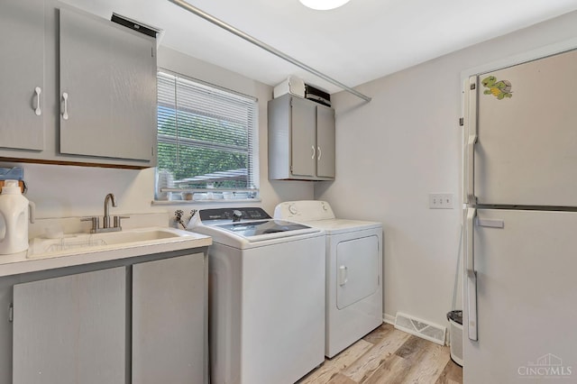 1366 Devils Backbone Rd, Green Twp, OH 45233 - laundry room featuring cabinet space, light wood-style flooring, separate washer and dryer, and baseboards