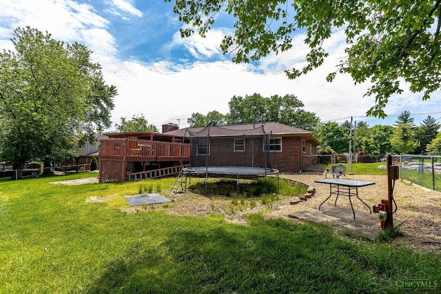 1366 Devils Backbone Rd, Green Twp, OH 45233 - rear view of property featuring a trampoline, a wooden deck, a chimney, and brick siding