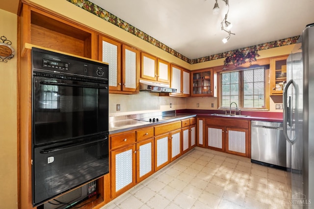 200 Santa Fe Rd, Middletown, OH 45042 - kitchen with black appliances, light flooring, under cabinet range hood, glass insert cabinets, and brown cabinets