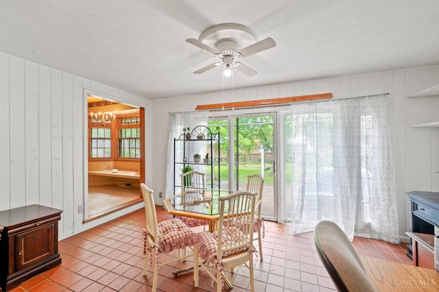 200 Santa Fe Rd, Middletown, OH 45042 - dining area featuring a chandelier, light tile patterned floors, ceiling fan, and wooden walls