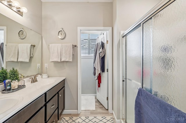 5859 Parkview Ln, Miami Twp, OH 45150 - bathroom with a stall shower, double vanity, wood finished floors, and baseboards