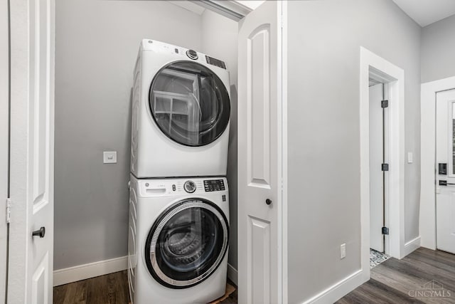4226 Chambers St, Cincinnati, OH 45223 - laundry room featuring stacked washer and clothes dryer, dark wood-style flooring, and baseboards