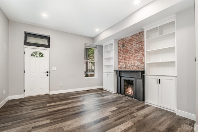 4226 Chambers St, Cincinnati, OH 45223 - unfurnished living room featuring baseboards, dark wood finished floors, a large fireplace, built in shelves, and recessed lighting