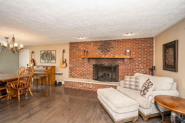 6290 Ludlum Rd, Salem Twp, OH 45152 - living room with a textured ceiling, wood finished floors, a brick fireplace, and a chandelier