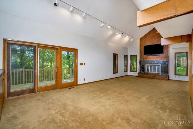4723 Rosedale Rd, Middletown, OH 45042 - unfurnished living room featuring track lighting, plenty of natural light, carpet floors, a large fireplace, and high vaulted ceiling