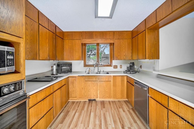 4723 Rosedale Rd, Middletown, OH 45042 - kitchen featuring appliances with stainless steel finishes, a sink, light wood finished floors, light countertops, and brown cabinetry