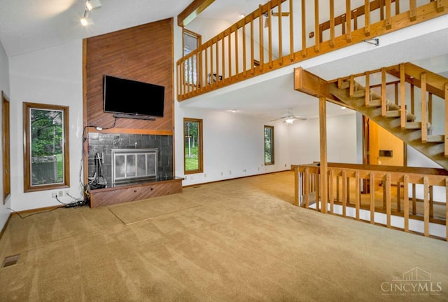 4723 Rosedale Rd, Middletown, OH 45042 - unfurnished living room with high vaulted ceiling, a large fireplace, carpet floors, a ceiling fan, and stairs