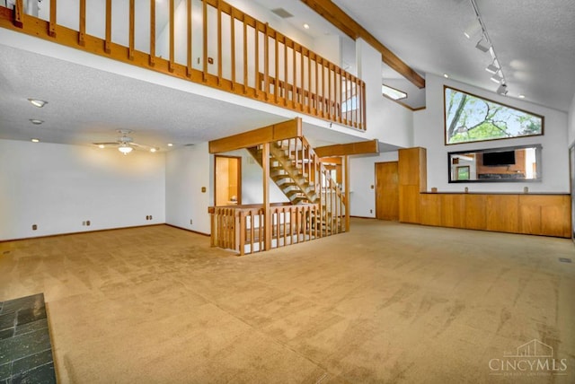 4723 Rosedale Rd, Middletown, OH 45042 - unfurnished living room with a textured ceiling, carpet flooring, a ceiling fan, rail lighting, and high vaulted ceiling