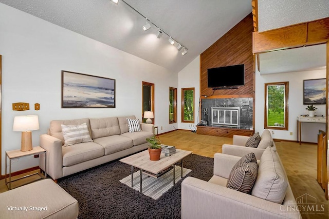 4723 Rosedale Rd, Middletown, OH 45042 - living area with rail lighting, a fireplace, high vaulted ceiling, and baseboards