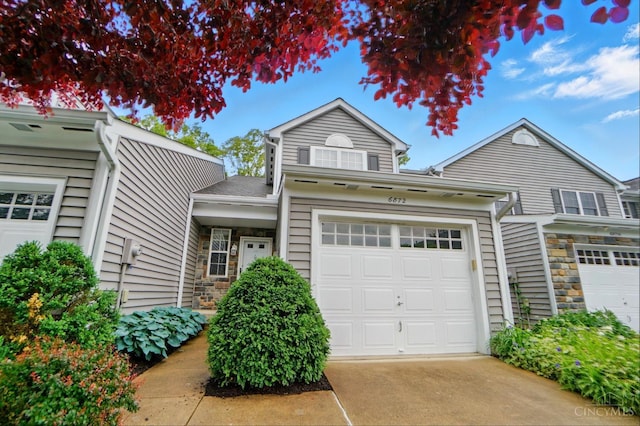 6872 Sandharbor Ct, Hamilton Twp, OH 45039 - traditional home with concrete driveway, a garage, and stone siding