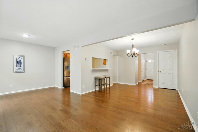 6872 Sandharbor Ct, Hamilton Twp, OH 45039 - unfurnished living room with wood finished floors, a chandelier, and baseboards