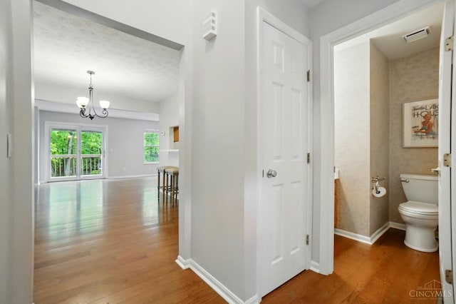 6872 Sandharbor Ct, Hamilton Twp, OH 45039 - hallway featuring wood finished floors, baseboards, and a chandelier