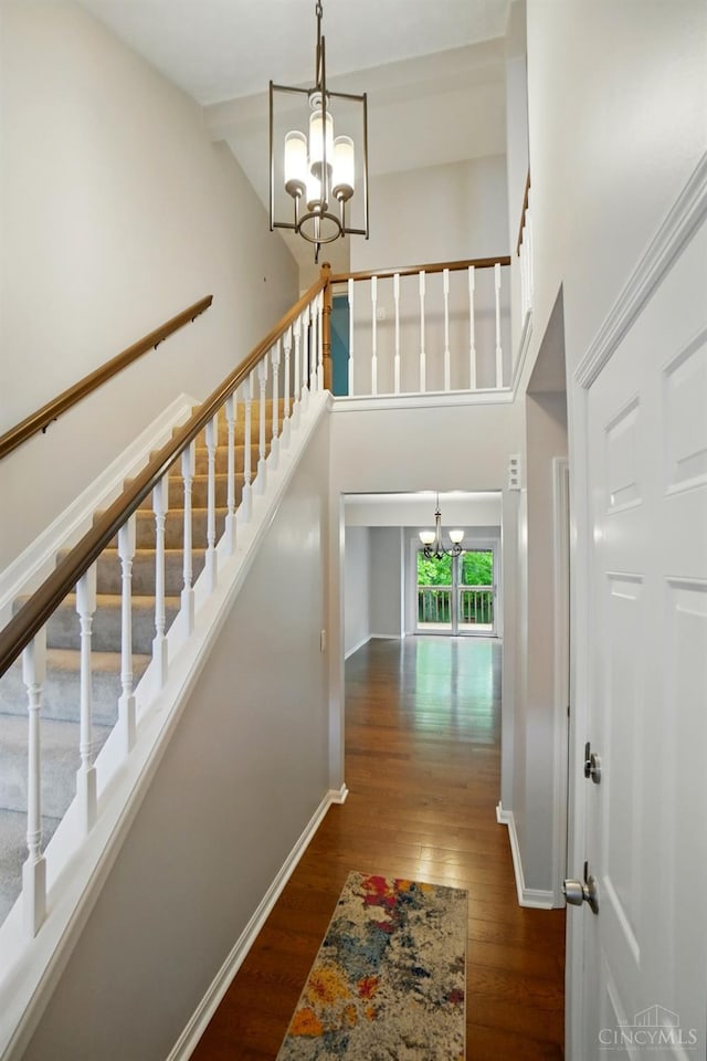 6872 Sandharbor Ct, Hamilton Twp, OH 45039 - stairs with a chandelier, wood finished floors, a towering ceiling, and baseboards