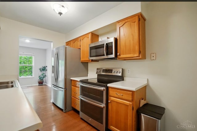 6872 Sandharbor Ct, Hamilton Twp, OH 45039 - kitchen with appliances with stainless steel finishes, light wood-style floors, light countertops, and brown cabinets