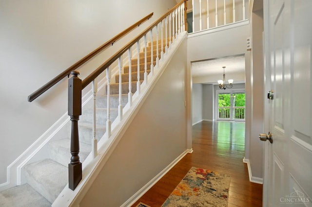 6872 Sandharbor Ct, Hamilton Twp, OH 45039 - stairway featuring wood finished floors, baseboards, and a chandelier