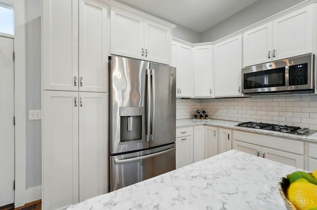 9276 Beacon St, Deerfield Twp, OH 45040 - kitchen featuring appliances with stainless steel finishes, decorative backsplash, white cabinets, and light stone counters