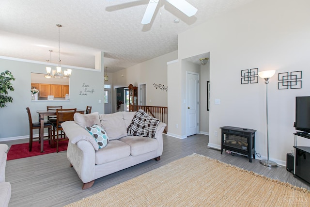 6260 Lake Front, Mason, OH 45040 - living area featuring wood finished floors, a textured ceiling, ceiling fan, a wood stove, and baseboards