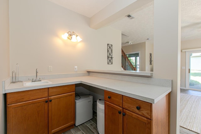 6260 Lake Front, Mason, OH 45040 - kitchen featuring a sink, light countertops, a textured ceiling, refrigerator, and brown cabinetry