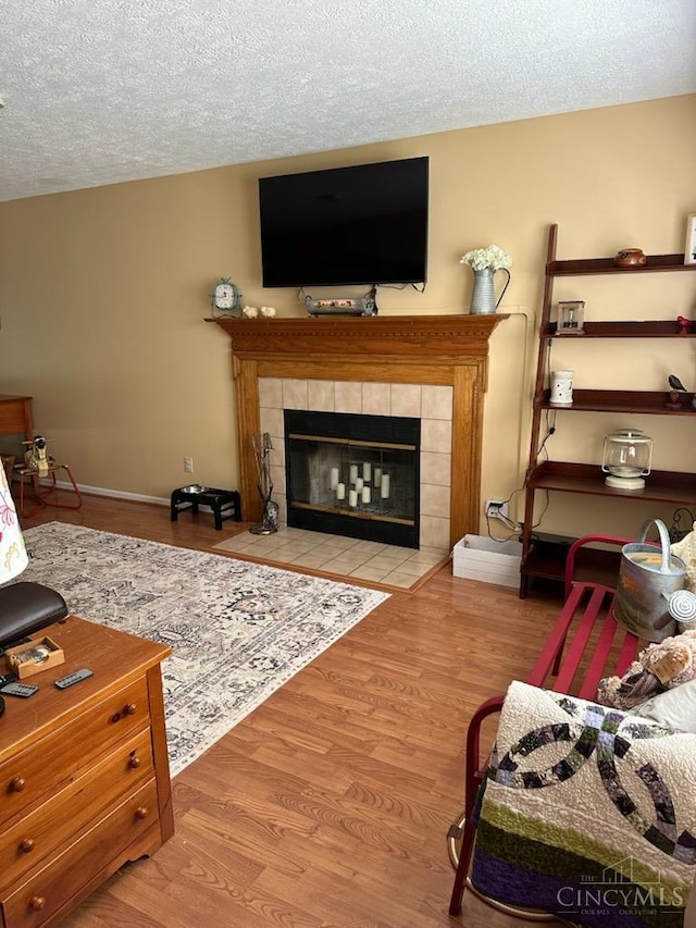 10773 New Biddinger Rd, Harrison Twp, OH 45030 - living room featuring a fireplace, wood finished floors, and a textured ceiling